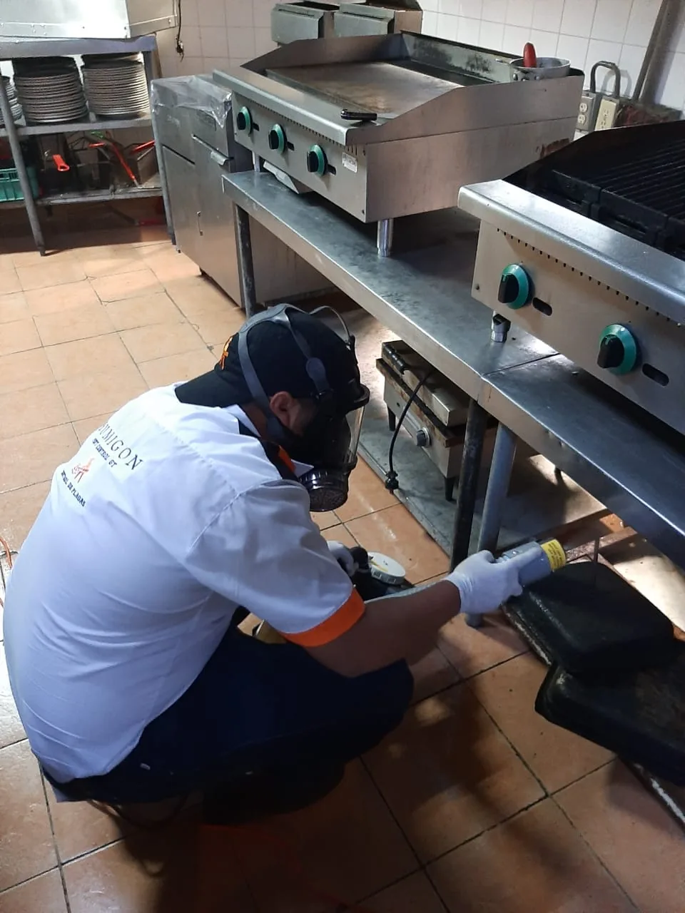 Técnico de Fumigón aplicando tratamiento en cocina